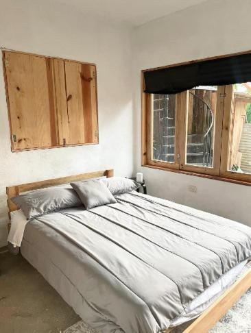 a bedroom with a large bed and a window at EB5 Escape-Contemporary Stay, San Marcos La Laguna #8 in San Marcos La Laguna