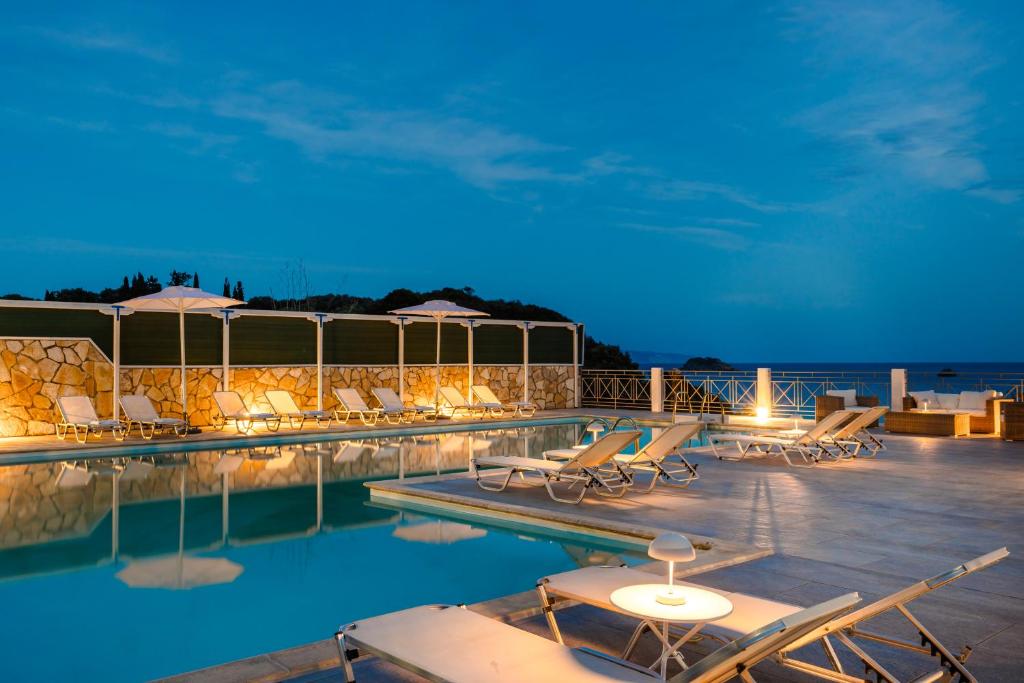 a swimming pool with lounge chairs and a resort at Costa Avithos in Svoronata