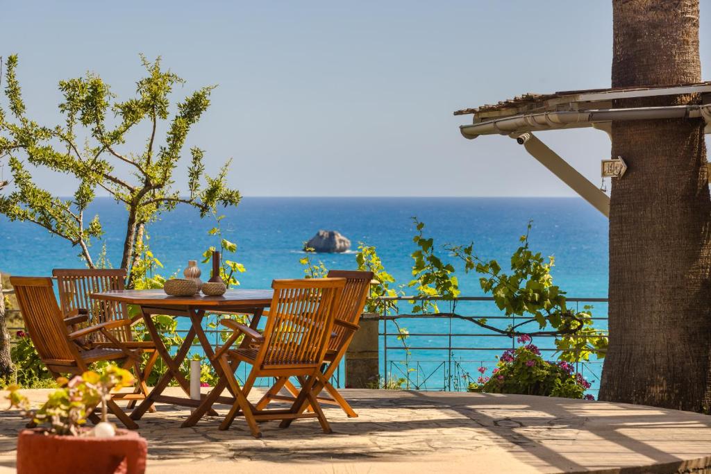 a table and chairs with the ocean in the background at Costa Avithos in Svoronata