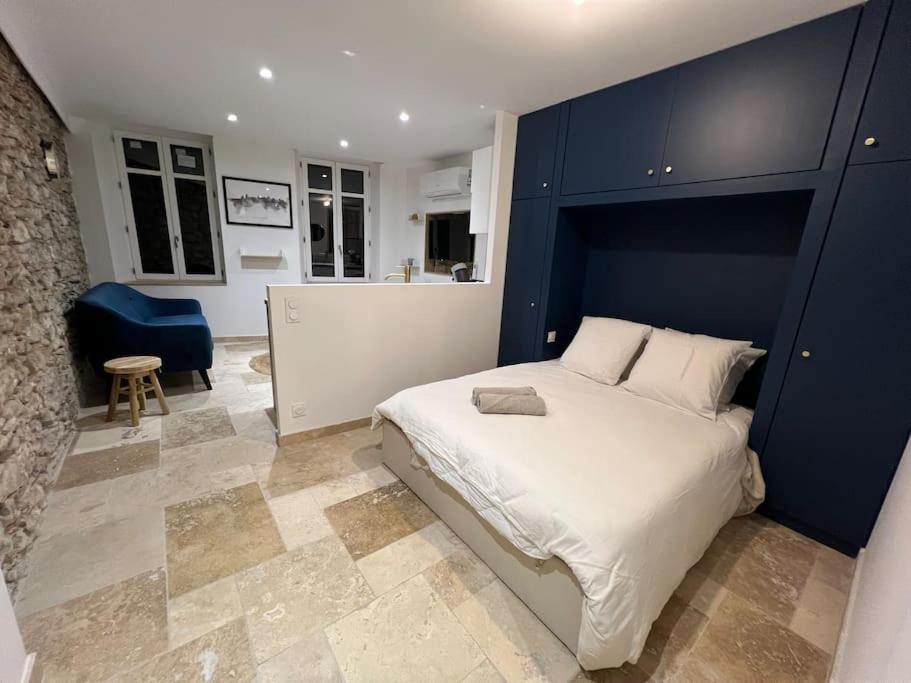 une chambre avec un grand lit avec une tête de lit bleue dans l'établissement Le Merveilleux Voyage, Clim, à Carcassonne