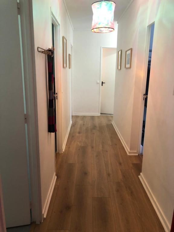 Un pasillo vacío con paredes blancas y pisos de madera. en BizFinding Paris, en Montrouge