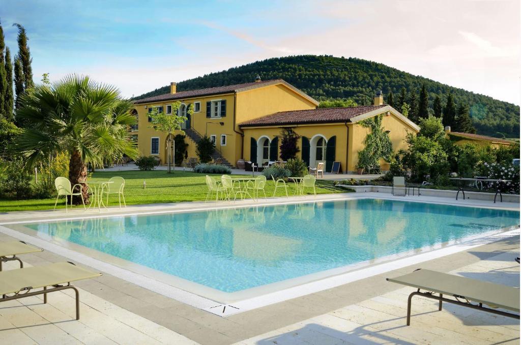 une grande piscine en face d'une maison dans l'établissement Wine Resort Ledà d'Ittiri, à Fertilia