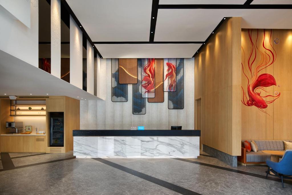 A reception lobby centered on a marble-fronted desk and colorful fish artwork.