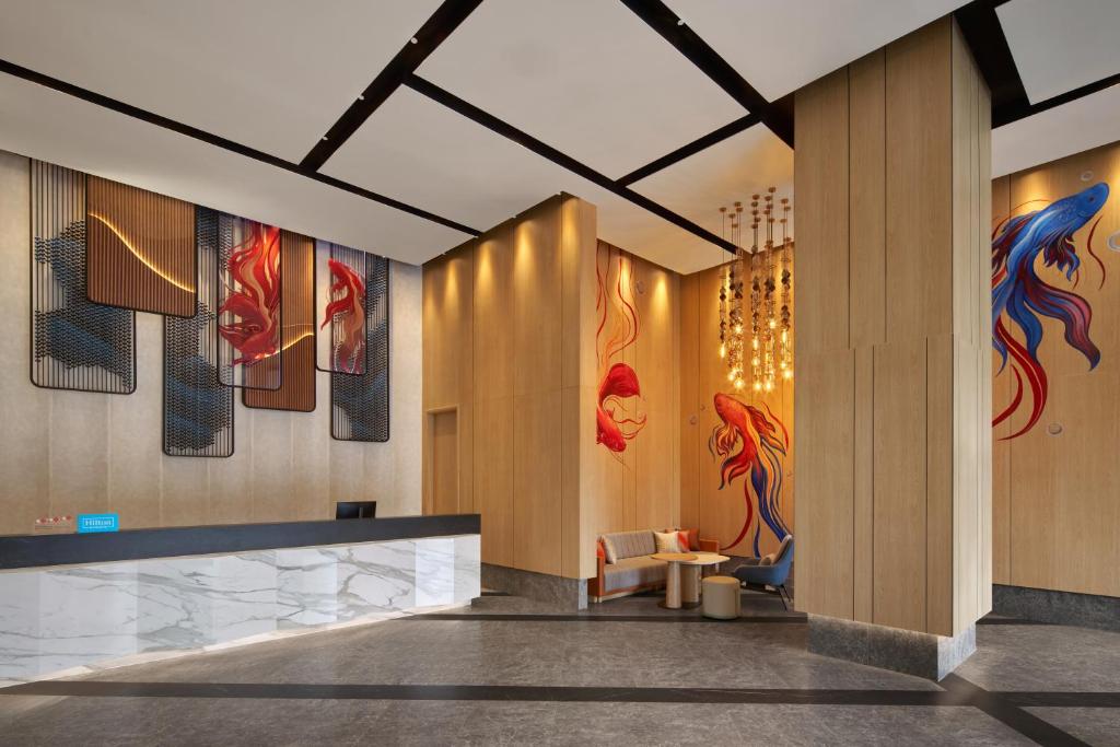 A reception area with a marble desk, fish artwork, and a small waiting nook.