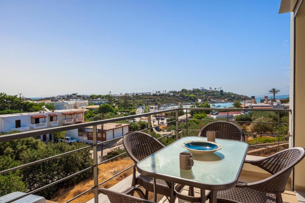 a table and chairs on a balcony with a view at Ormos Sea View Apartment in Agios Nikolaos
