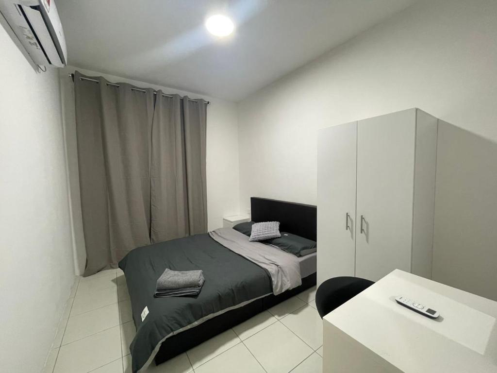 a bedroom with a bed and a white cabinet at Anderson 2 room Ipoh city center in Ipoh