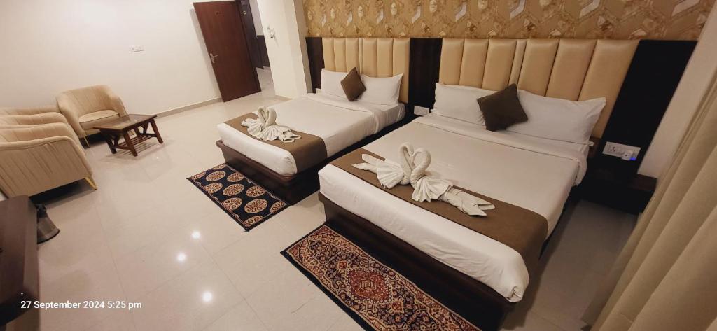 AyodhyaNeelkanth Hotel的酒店客房,配有两张带鲜花的床