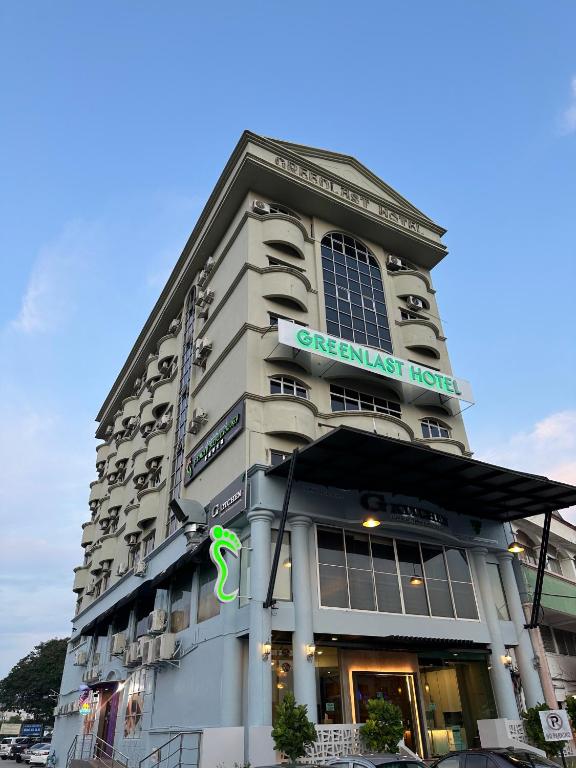 a large building with a green sign on it at Greenlast Hotel in Kuantan
