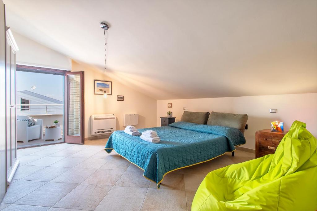 een slaapkamer met een bed en een groot raam bij Non dire Gatto - Elegant Rooftop in Alghero