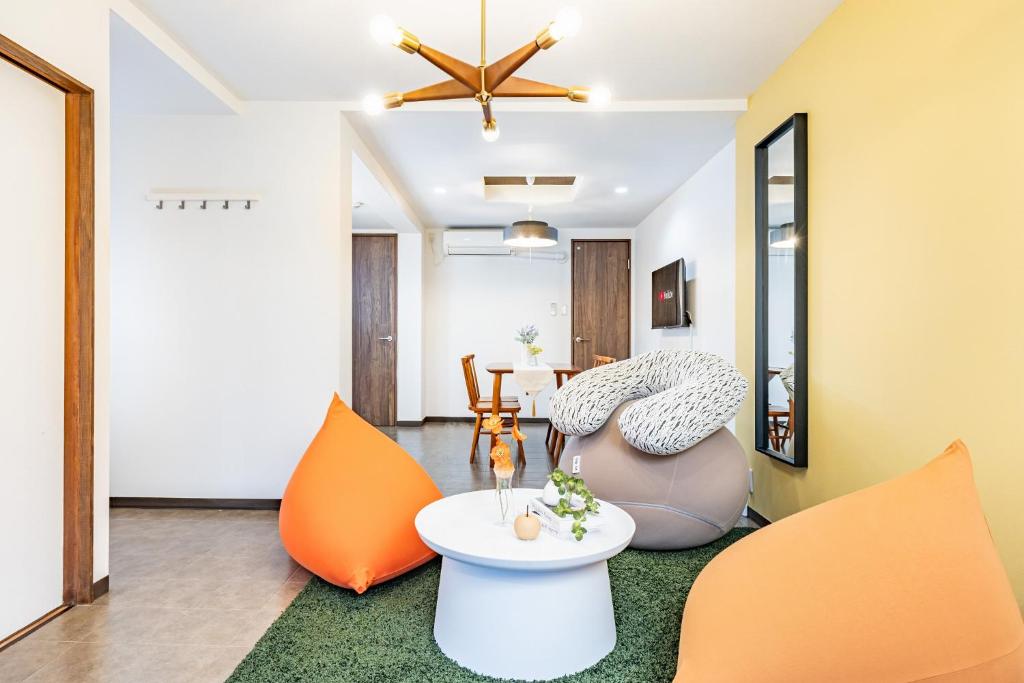a living room with orange chairs and a table at Bijou Suites Ten in Osaka