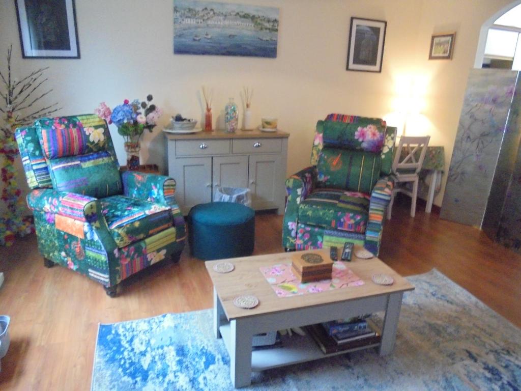 a living room with two chairs and a table at 3 Station Court, Munlochy in Munlochy