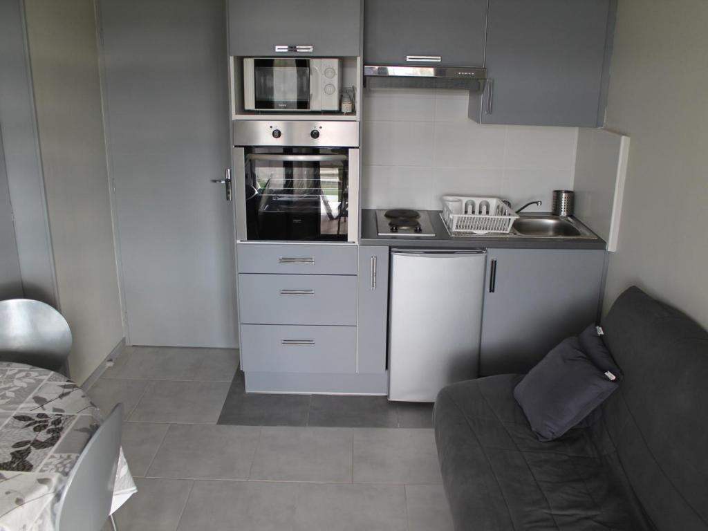 une petite cuisine avec une cuisinière et un micro-ondes dans l'établissement Charmant T2 avec terrasse et Wi-Fi à 100m des Thermes - FR-1-541-130, à La Roche-Posay