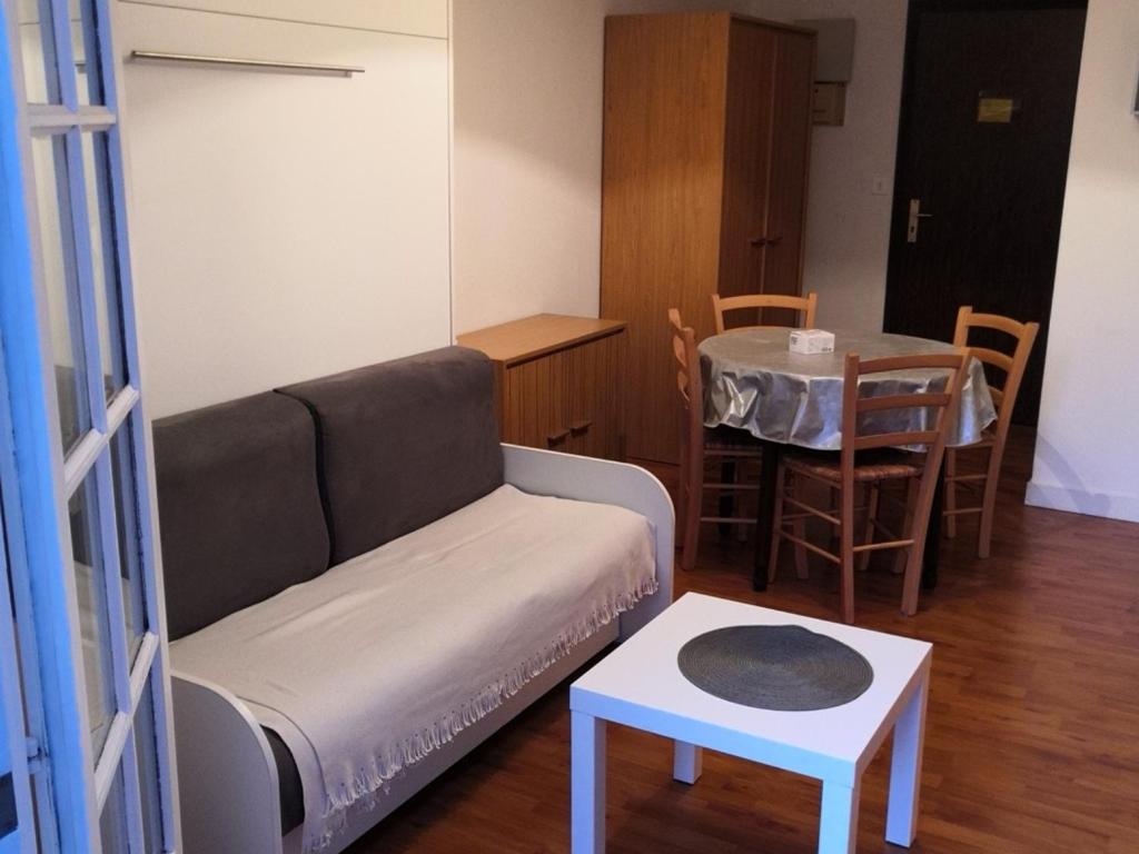 un salon avec un canapé et une table dans l'établissement Appartement meublé avec balcon - Animaux admis, WiFi - FR-1-541-146, à La Roche-Posay