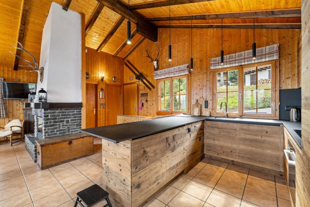 a kitchen with wooden walls and a large island with a counter at Eole - 6 pers - pres des pistes in Nendaz