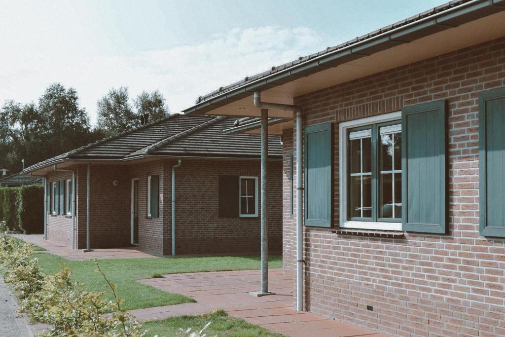 a brick house with a pitched roof at Grijze Veen 8-person bungalow in Voorthuizen
