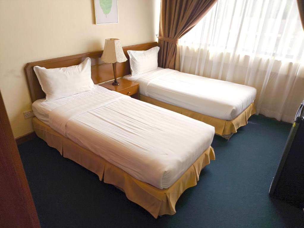 Postel nebo postele na pokoji v ubytování Jubilee Hotel