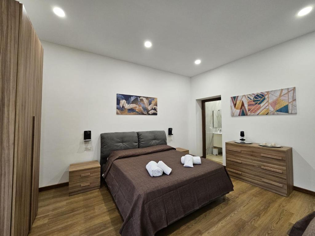 Be Your Home - La Darsena Guest House في تشيفيتافيكيا: غرفة نوم بها سرير عليه منشفتان