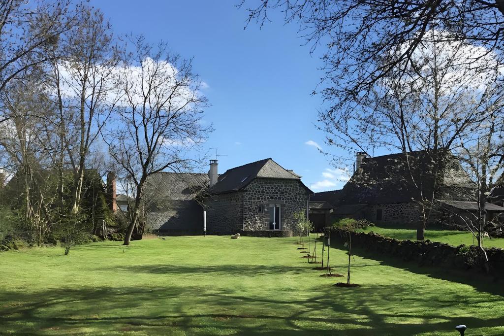 une maison avec une cour d'herbe devant elle dans l'établissement Grange 1850 entièrement rénovée, à Lacroix-Barrez