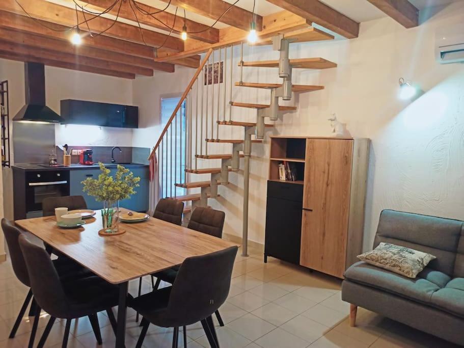 - une cuisine et une salle à manger avec une table en bois et des escaliers dans l'établissement Gite de l'Auzon Vallon Pont d'Arc 3ch, à Vallon-Pont-dʼArc