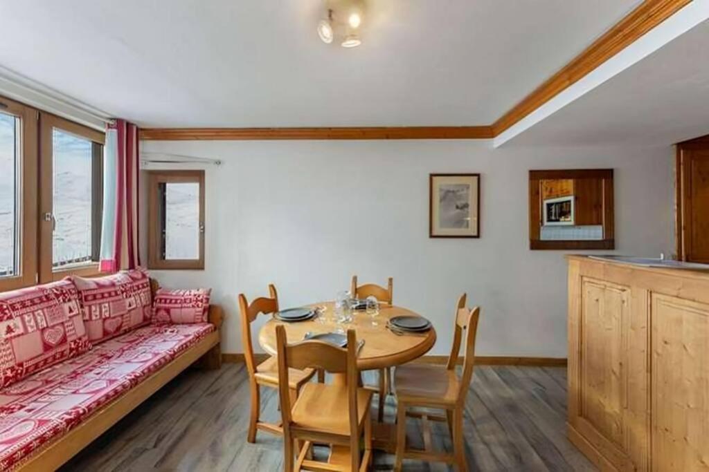ein Wohnzimmer mit Tisch und Couch in der Unterkunft Arcelle Condo by Alpstays in Val Thorens