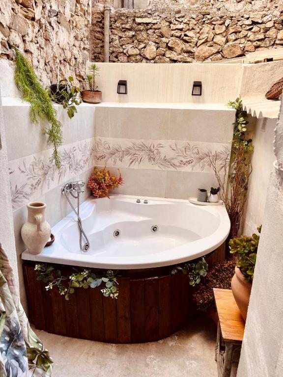 a bath tub in a bathroom with a stone wall at Casa Cercana in Abarán