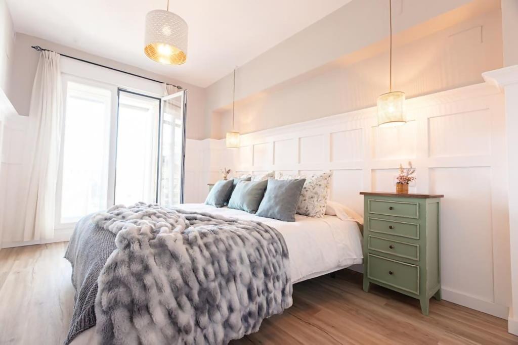 une chambre blanche avec un lit et une commode verte dans l'établissement Moraima parking incluido, à Sierra Nevada