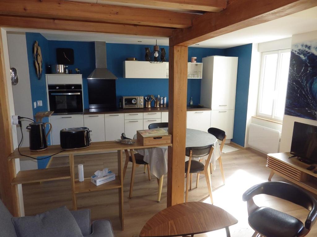 une cuisine avec une table et des chaises dans une pièce dans l'établissement la vague, à Les Sables-dʼOlonne