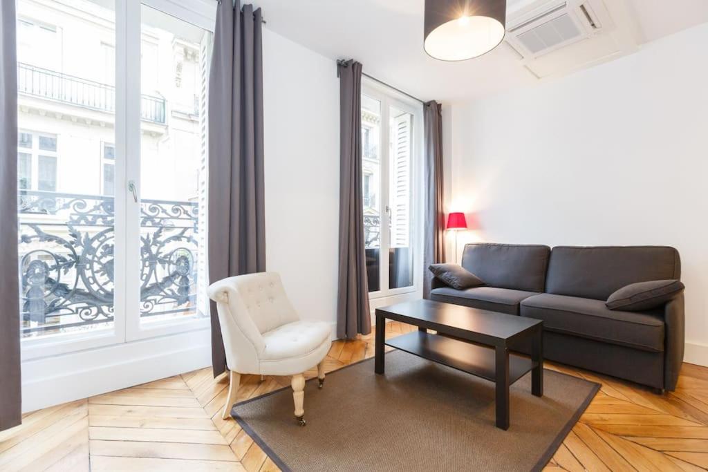 un salon avec un canapé, une table et une chaise dans l'établissement Appartement 2 pièces confortable, à Paris