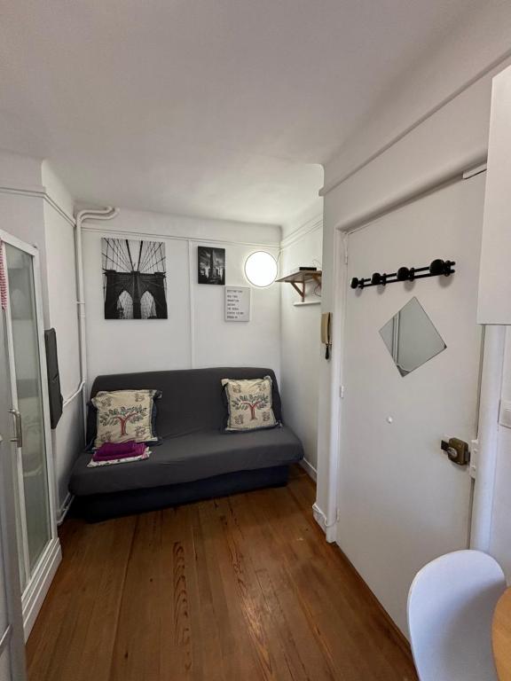 un salon avec un canapé bleu dans une pièce dans l'établissement Studio 300m de la plage, au Havre