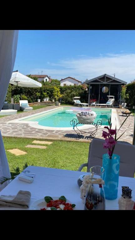 a table with flowers on it next to a swimming pool at Rossodisera in Sarzana
