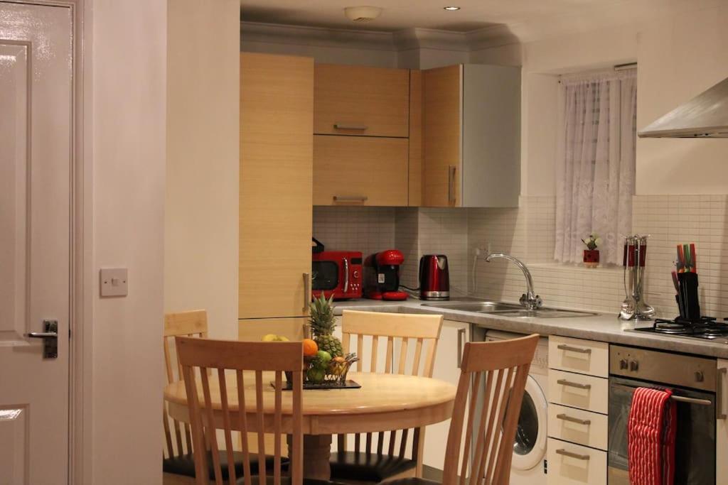 a kitchen with a table and chairs in a kitchen at Eldridge Court Apartment - 1 bedroom in Dagenham