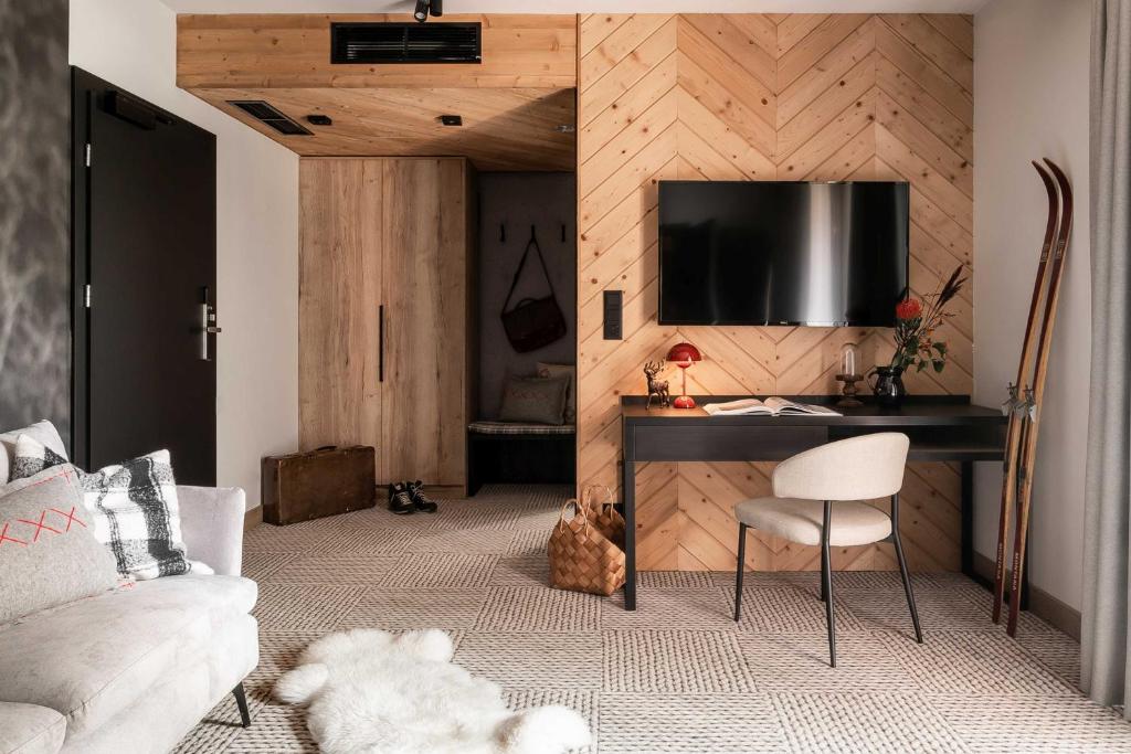 a living room with a desk and a tv on a wall at Stefanova Zakopane Aparthotel & Spa in Zakopane