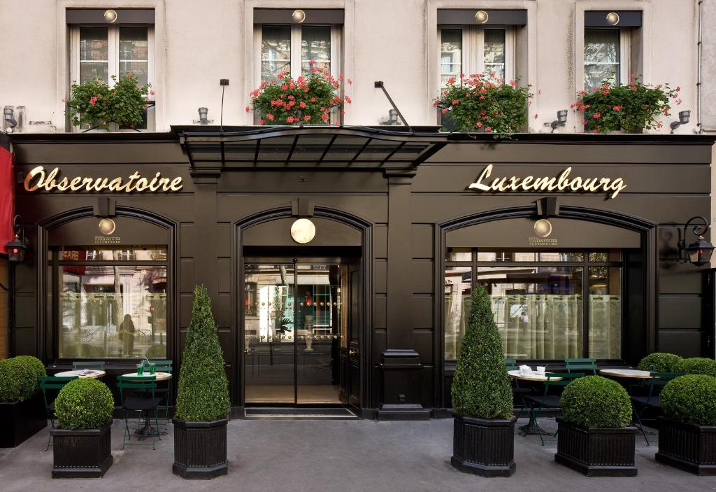 un restaurant avec des tables en face d'un bâtiment dans l'établissement Hotel Observatoire Luxembourg, à Paris