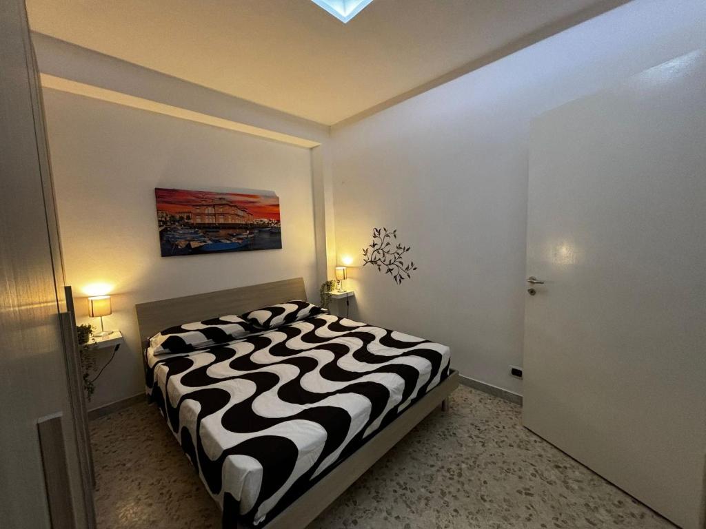 ein Schlafzimmer mit einem schwarz-weißen Bett in einem Zimmer in der Unterkunft Cavour Housing in Bari