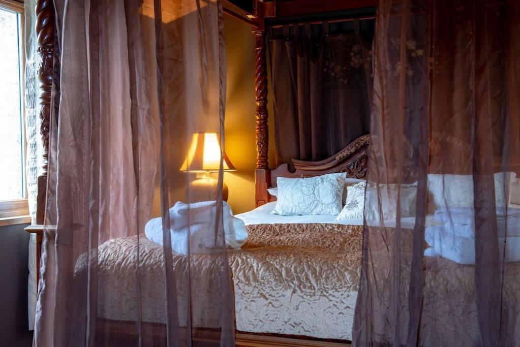 a bedroom with a canopy bed with curtains at Beveren Lodge - Still Rabbit - Hot Tub - Yorkshire in Selby