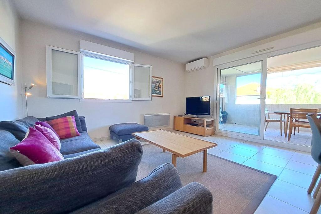 un salon avec un canapé et une table dans l'établissement 3BR in Cannes with Swimming Pool Terraces Parking & AC - BENAKEY, à Cannes