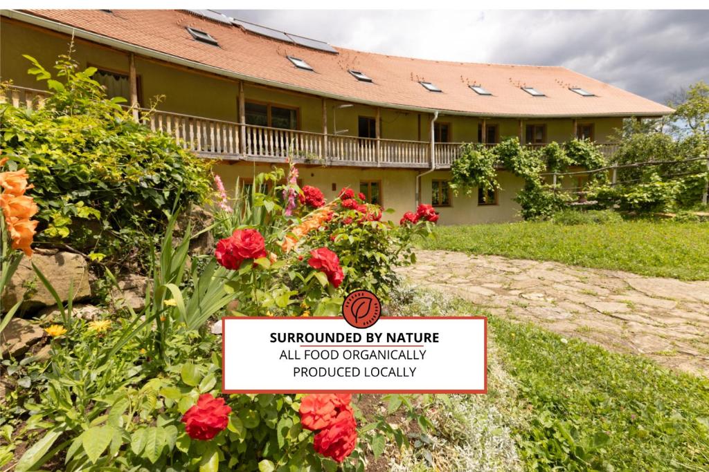 a house with a sign in front of it with flowers at Natura Planinca in Kalobje