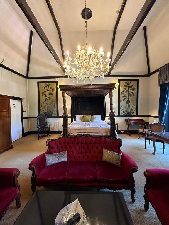a living room with a bed and a red couch at Langtry Manor Hotel in Bournemouth