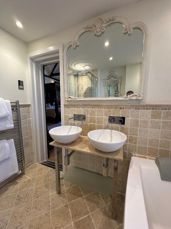 a bathroom with two sinks and a large mirror at Langtry Manor Hotel in Bournemouth