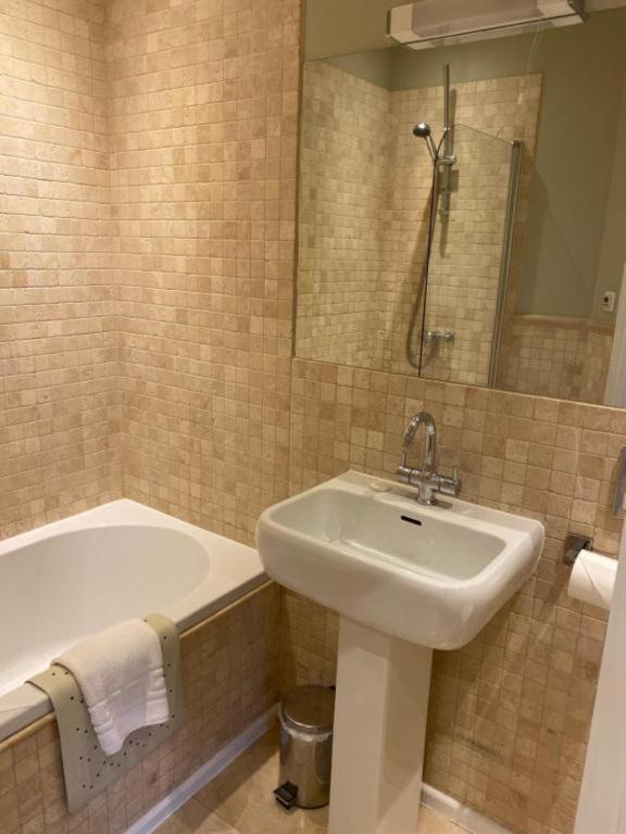 a bathroom with a sink and a bath tub and a sink at Langtry Manor Hotel in Bournemouth
