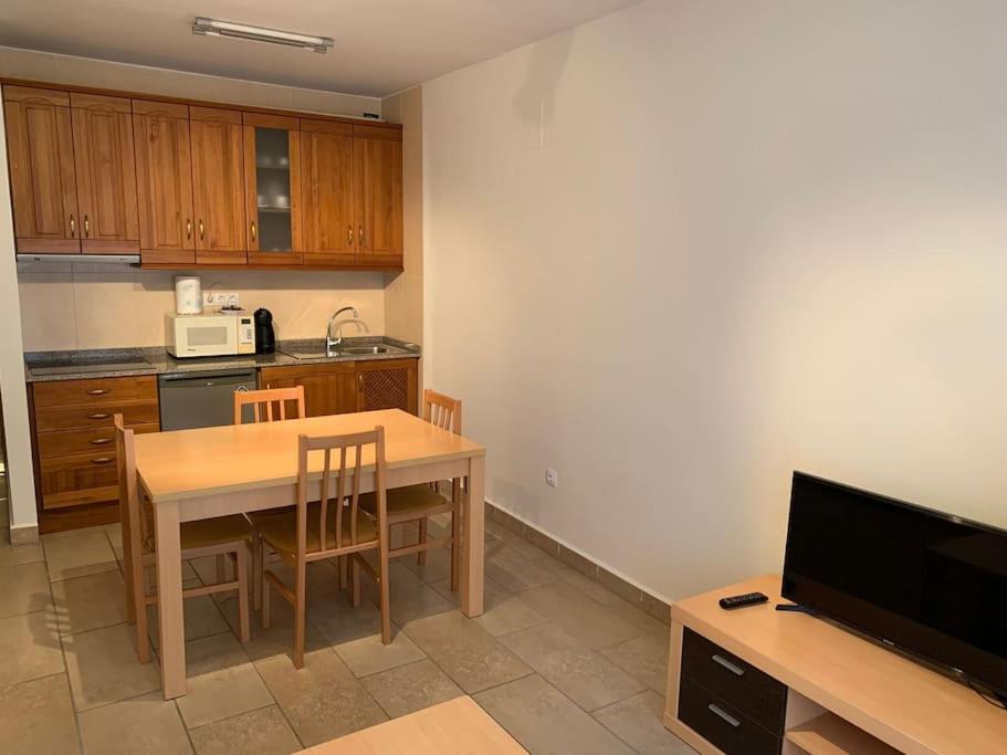 a kitchen with a wooden table and a dining room at Apartamento Camarena de La Sierra in Camarena de la Sierra