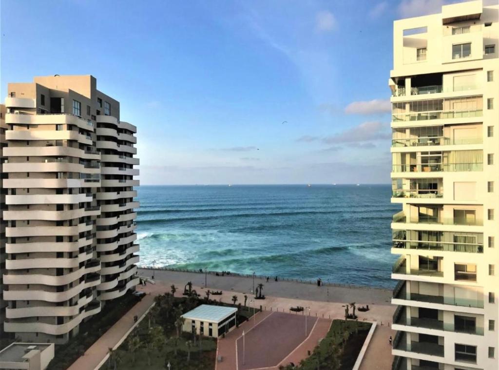 a view of the ocean from between two buildings at Marina casablanca in Casablanca