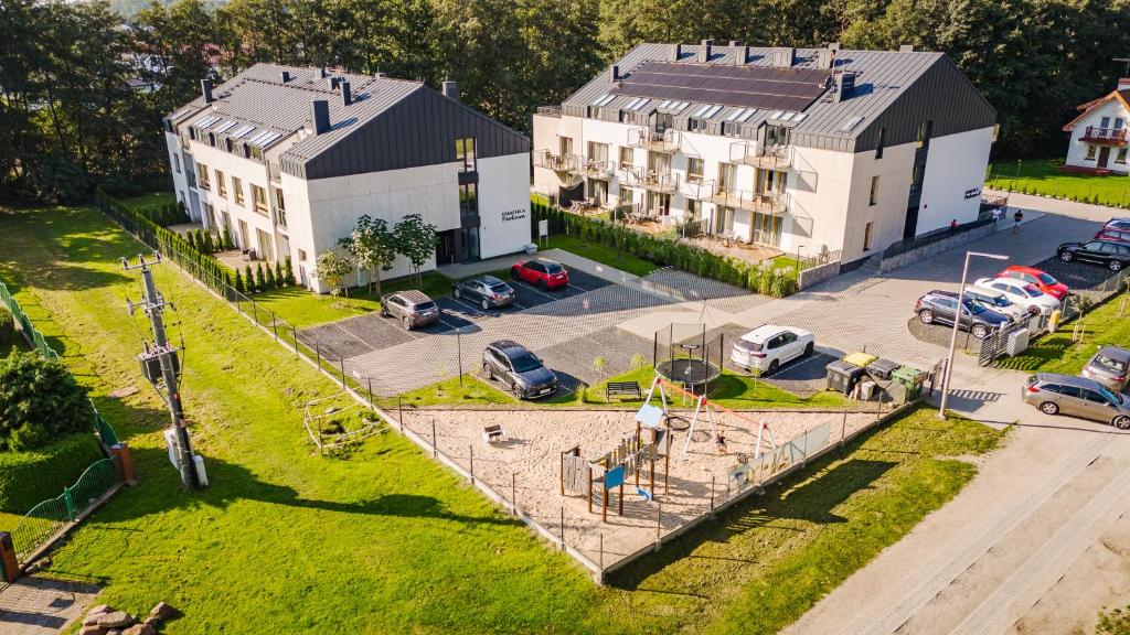 an aerial view of a parking lot with two buildings at Kamienica Parkowa in Dąbki