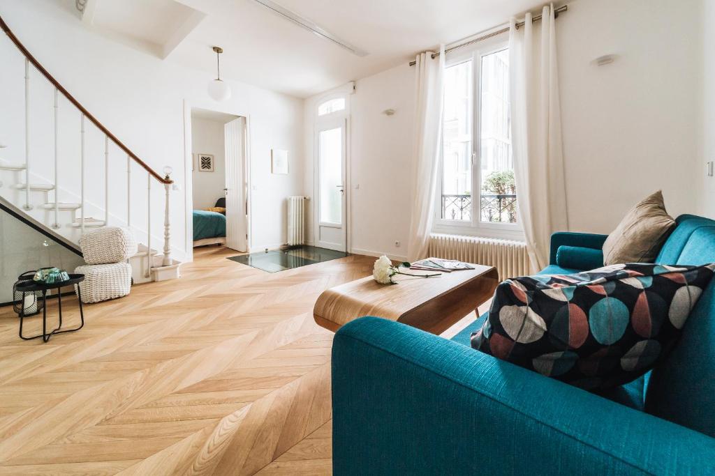 un salon avec un canapé bleu et un parquet dans l'établissement Joli Hotel Particulier proche du jardin du Luxembourg, à Paris