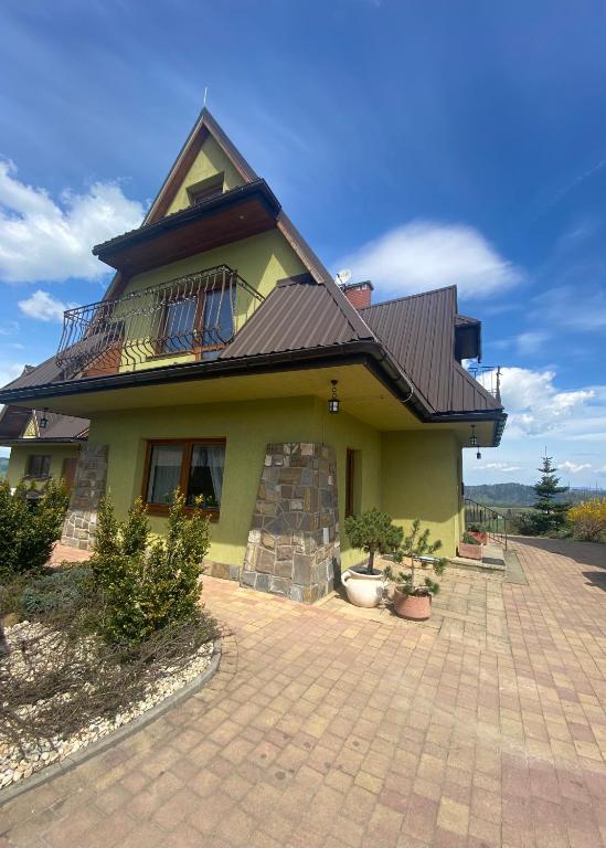 a yellow house with a balcony on top of it at Domki JAWOR in Zakopane