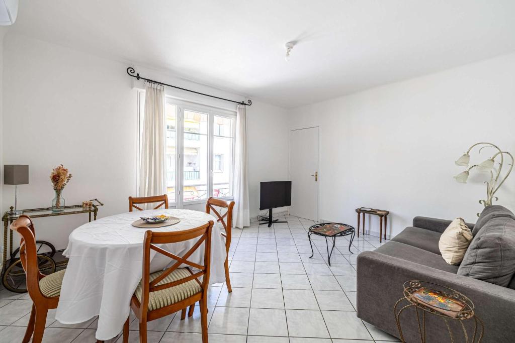 un salon avec une table et un canapé dans l'établissement LE CONNEMARRA avec balcon, lumineux et calme à côté du centre, à Cannes