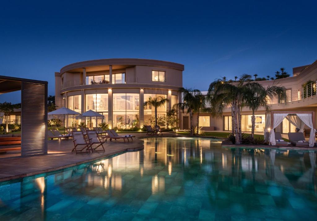 a large house with a swimming pool at night at Ailla Yalıkavak in Yalıkavak