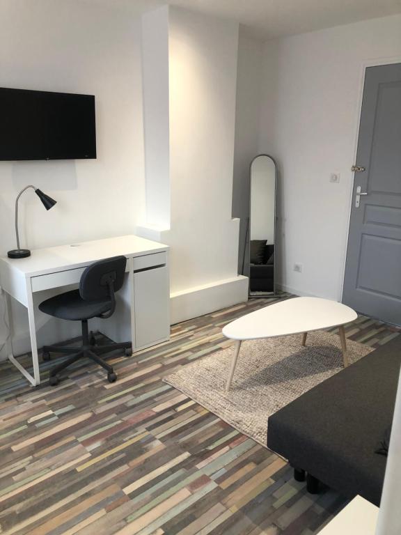 ein Büro mit einem Schreibtisch, einem Stuhl und einem Tisch in der Unterkunft Dream house in Lille