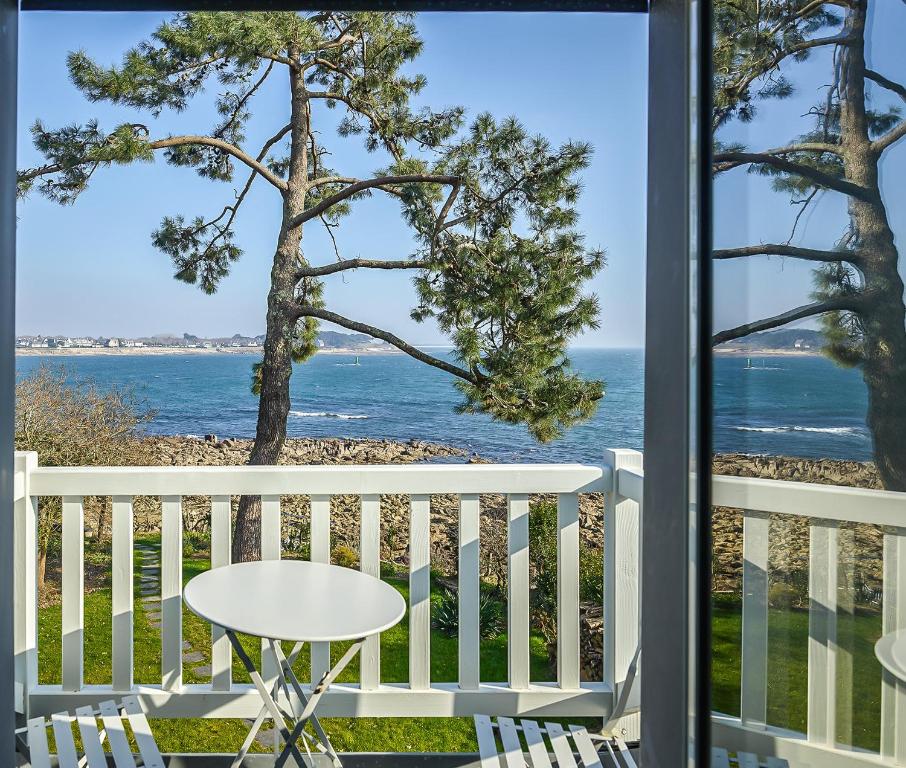 une table et des chaises sur un balcon avec vue sur l'océan dans l'établissement Mazi Bihan, à Combrit