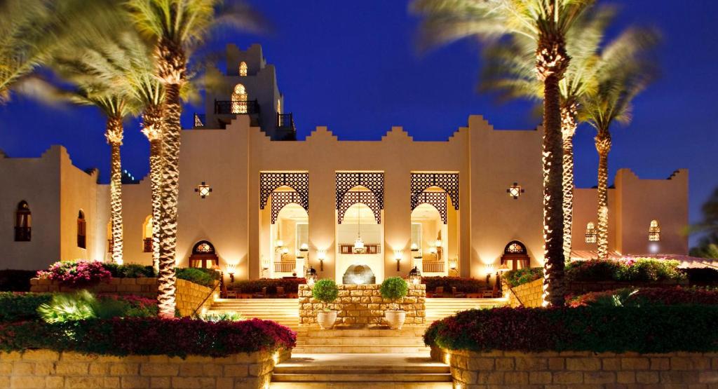 un grande edificio con palme di fronte di Four Seasons Resort Sharm El Sheikh Private Residential Villa & Chalet - Egypt a Sharm El Sheikh